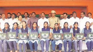 Tamil Nadu’s school education minister K A Sengottaiayan distributing free laptop computers to students.