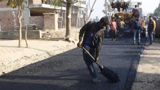 A worker at the construction site of the first plastic road in the city, at Sector 51, in Gurugram.